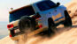 A 4x4 vehicle driving over golden sand dunes, representing the Best Desert Adventures in Qatar