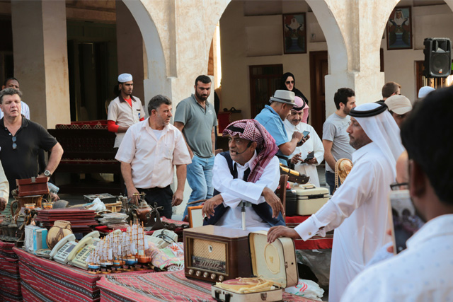 Traditional market scene at Souq Waqif in Doha, Qatar, featuring vendors and antique items.