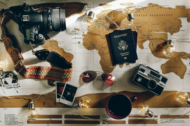 A travel map with a coffee cup and a passport on a table, symbolizing travel planning and the importance of travel insurance.